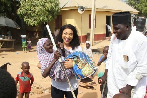 Tonto Dikeh All Smiles As She Carries Crippled Woman During Visit To Physically Challenged People In Abuja 