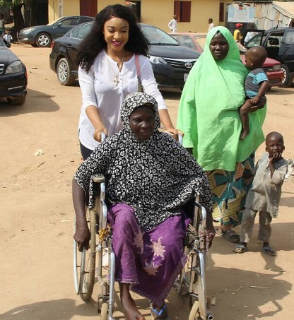 Tonto Dikeh All Smiles As She Carries Crippled Woman During Visit To Physically Challenged People In Abuja 