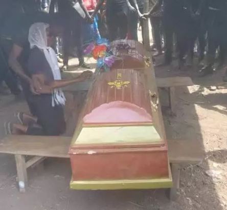 girlfriend kneels before the coffin of her late boyfriend to pay her last respect