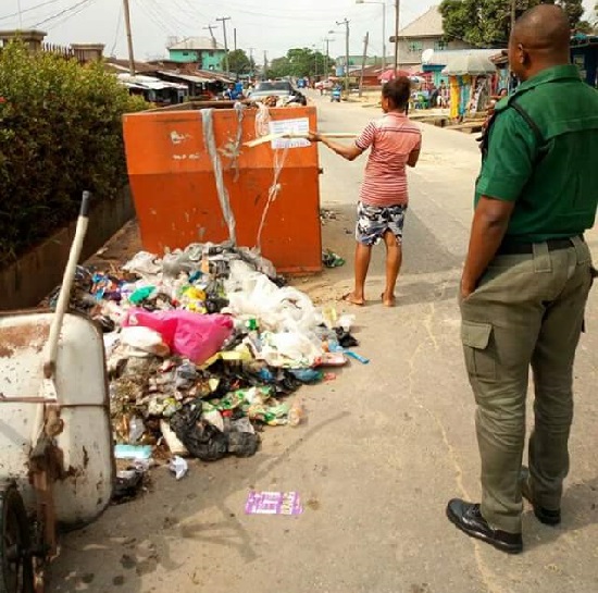 Lady Caught Dumping A Refuse On The Ground Besides Half Empty Bin In Calabar Ordered To Clear Up A Dumping Site [Photos]