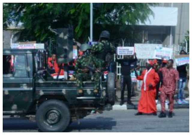 Security personnel control crowd outside the court